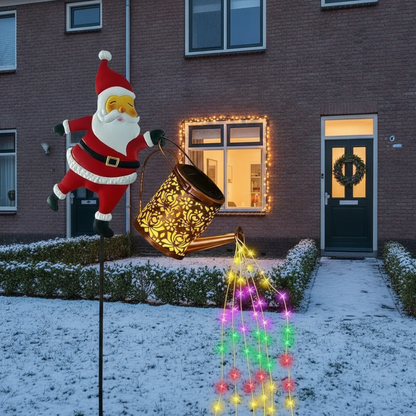 Cascada Solar-Weihnachtsmann mit mehrfarbigem Lichtwasserfall vor einem Reihenhaus im Schnee